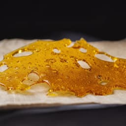 Macro of translucent amber cannabis shatter